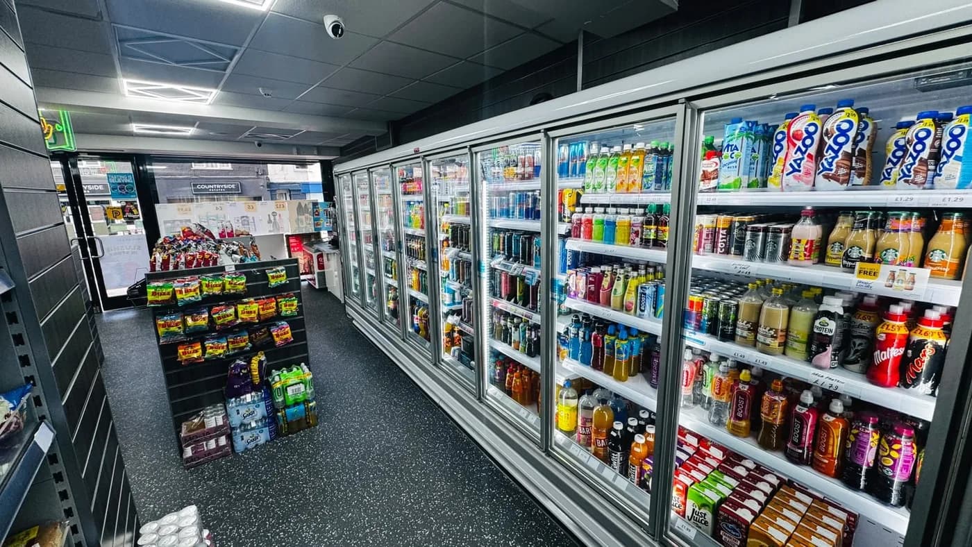 Milk, chilled drinks and grocery shelves inside Coco Local